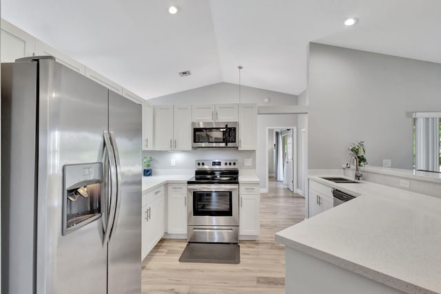 kitchen featuring sink, stainless steel appliances, vaulted ceiling, white cabinets, and light wood-type flooring