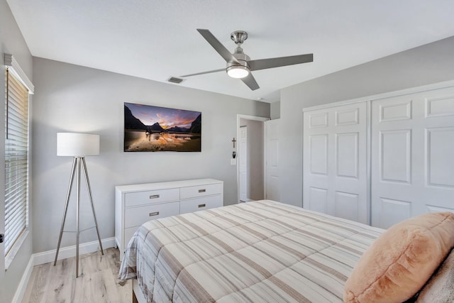 bedroom with ceiling fan, light hardwood / wood-style floors, and a closet