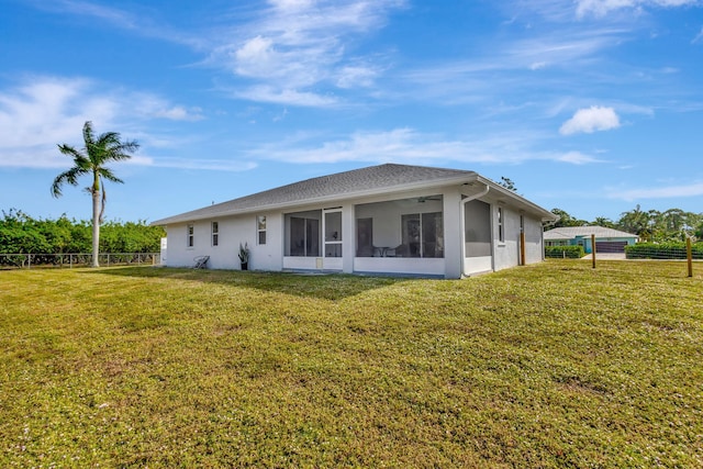 rear view of property with a sunroom and a yard