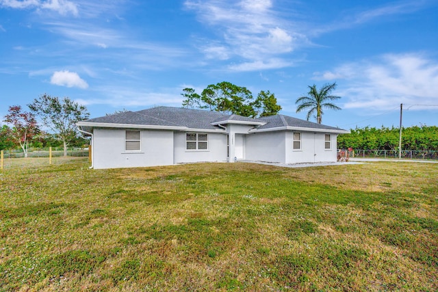 rear view of property featuring a yard