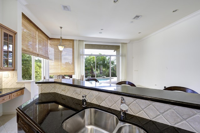 kitchen featuring light tile patterned flooring, sink, tasteful backsplash, crown molding, and hanging light fixtures