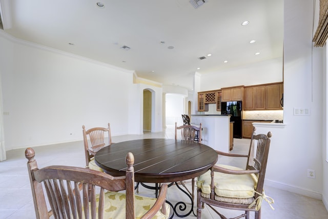 dining area with ornamental molding and light tile patterned floors