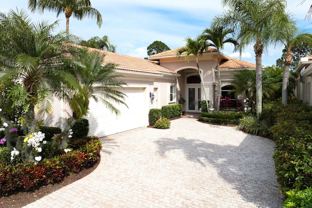 mediterranean / spanish-style home featuring a garage and french doors