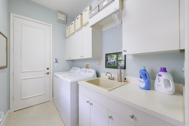 laundry area featuring cabinets, washing machine and dryer, sink, and light tile patterned floors