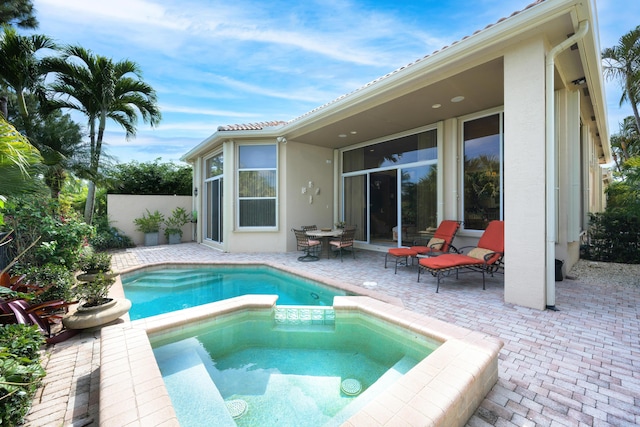 view of swimming pool featuring a patio and an in ground hot tub