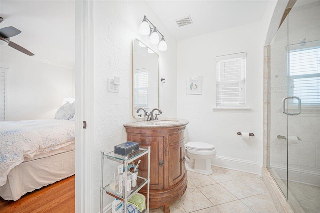 bathroom with vanity, tile patterned flooring, ceiling fan, toilet, and walk in shower