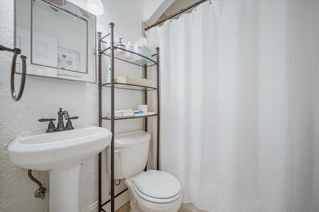 bathroom with a shower with curtain and toilet