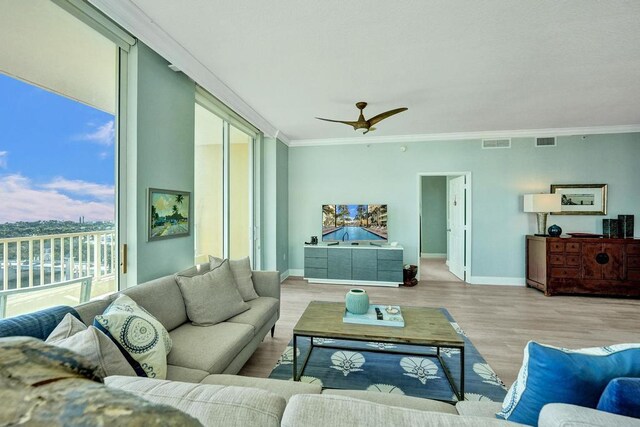 living room featuring light wood-type flooring, ceiling fan, and crown molding