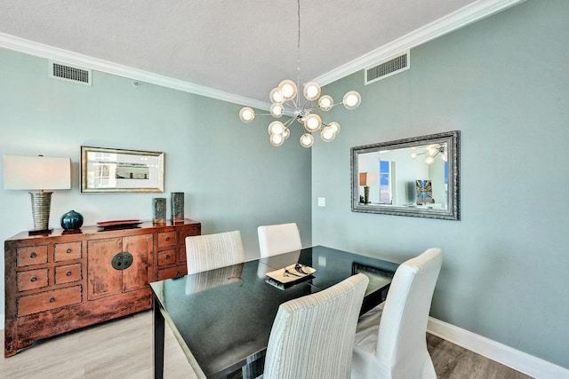 dining area with light hardwood / wood-style flooring, a chandelier, and ornamental molding