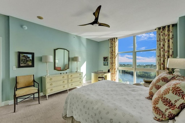 carpeted bedroom with ceiling fan and a water view