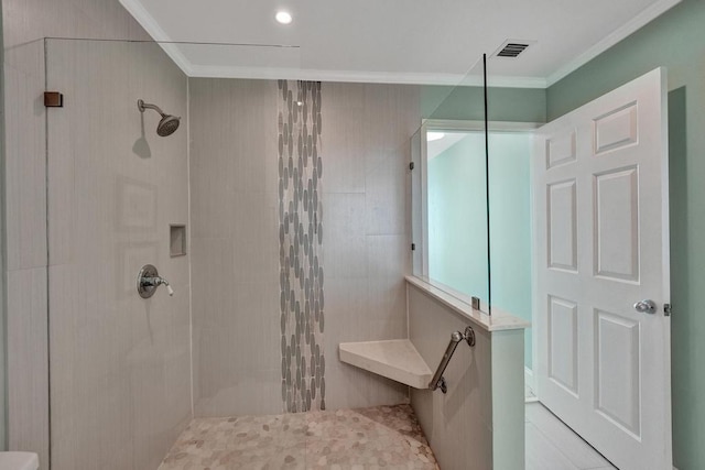 bathroom featuring a tile shower and ornamental molding