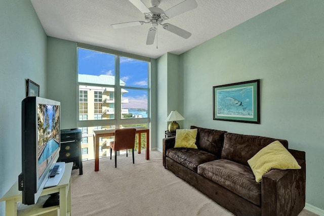 carpeted living room with ceiling fan and a textured ceiling