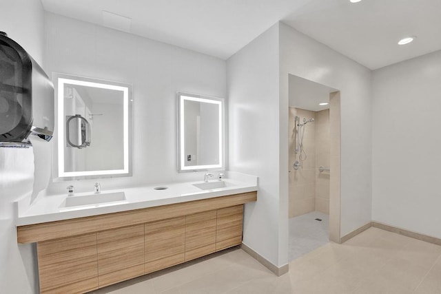 bathroom with tiled shower, vanity, and tile patterned floors