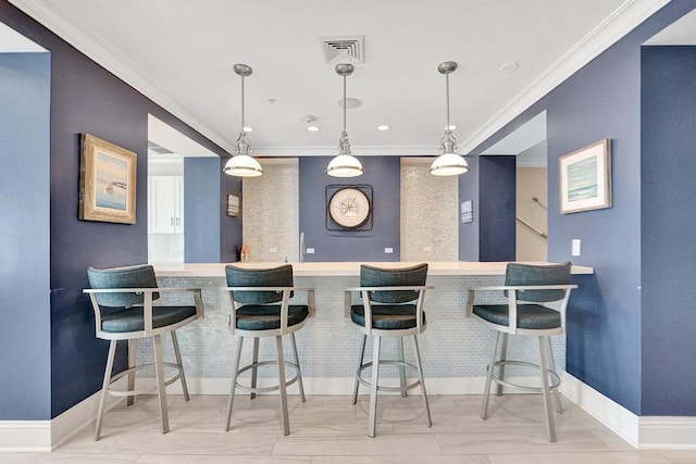 kitchen with a breakfast bar area, decorative light fixtures, and ornamental molding