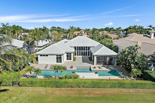 rear view of property featuring a sunroom, a patio area, and a yard