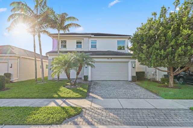 traditional home featuring a garage, decorative driveway, a front yard, and stucco siding