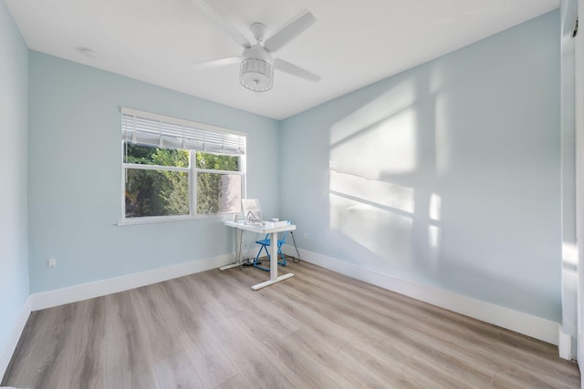 unfurnished room with a ceiling fan, baseboards, and wood finished floors