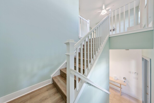 stairway featuring ceiling fan