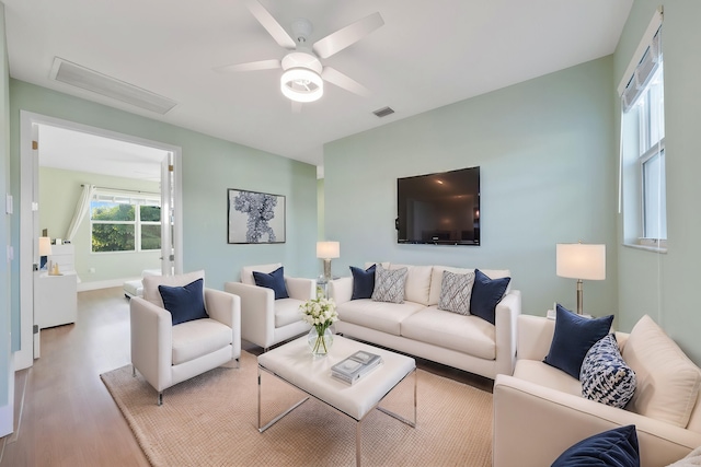 living area with visible vents, ceiling fan, and wood finished floors