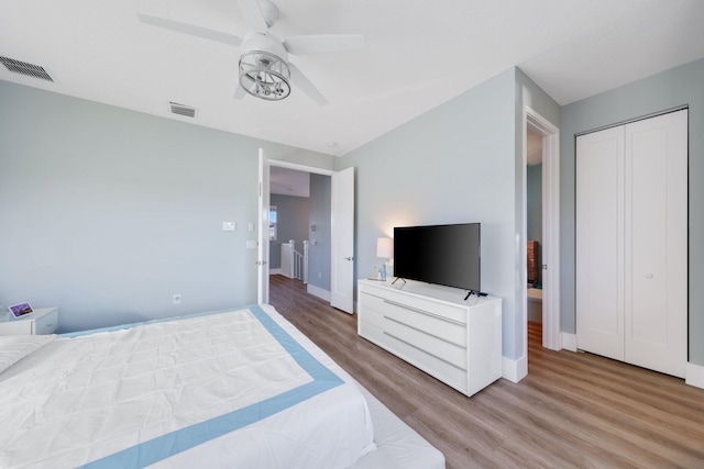 bedroom with a ceiling fan, a closet, visible vents, and wood finished floors