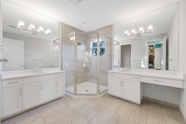 bathroom with a stall shower, two vanities, and a sink