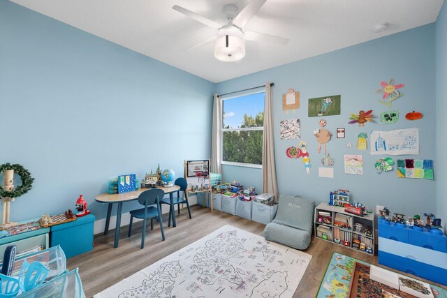 playroom with ceiling fan and light hardwood / wood-style floors