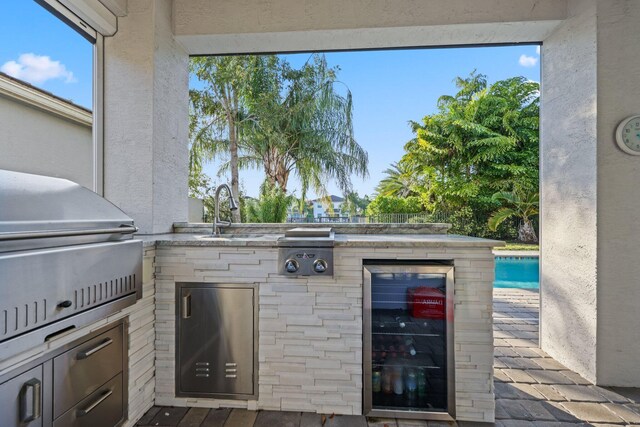 view of patio / terrace featuring a grill, wine cooler, exterior kitchen, and sink