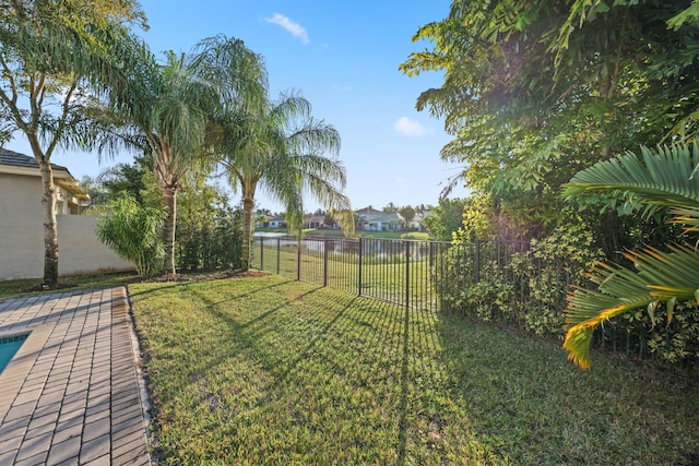 view of yard featuring a water view and a fenced backyard