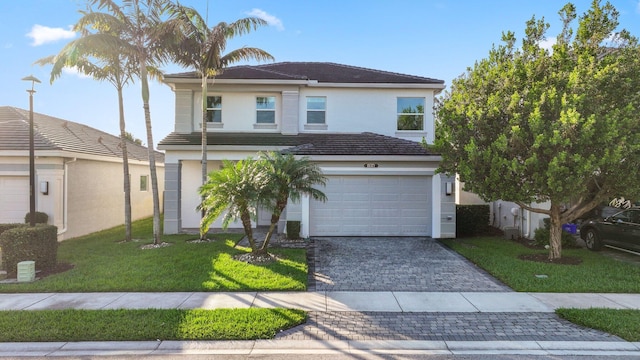 traditional-style home featuring decorative driveway, a tiled roof, a front lawn, and stucco siding