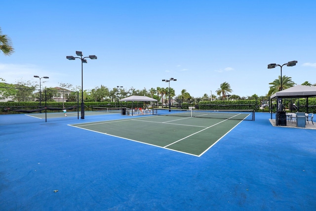 view of tennis court featuring a gazebo and fence