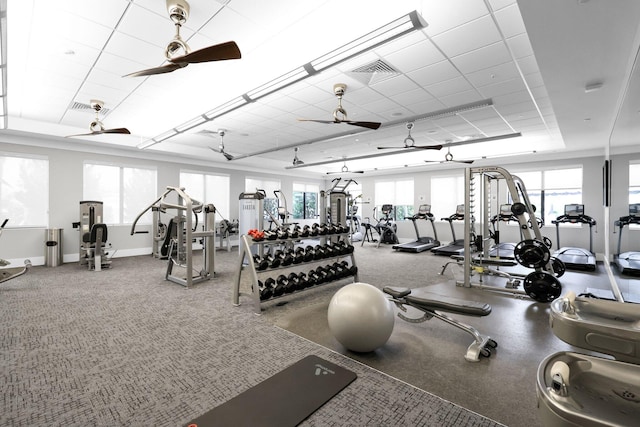 exercise room with a ceiling fan, a paneled ceiling, visible vents, and baseboards