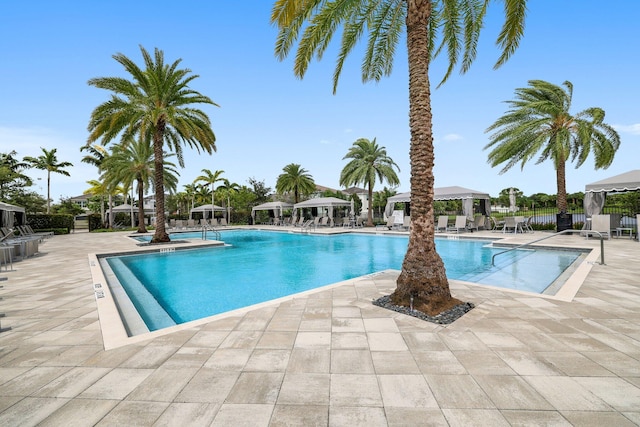 community pool featuring a patio area, fence, and a gazebo