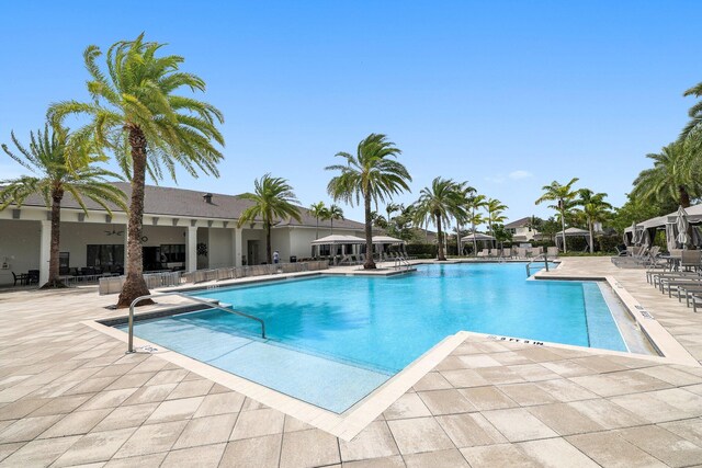 view of swimming pool with pool water feature and a patio area