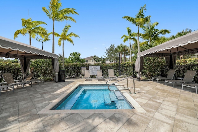 view of swimming pool with a patio area, a swimming pool, fence, and a gazebo