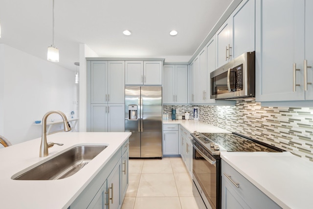 kitchen with decorative light fixtures, backsplash, sink, appliances with stainless steel finishes, and light tile patterned floors