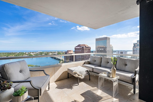 balcony featuring an outdoor living space and a water view