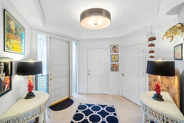 tiled foyer entrance featuring a tray ceiling