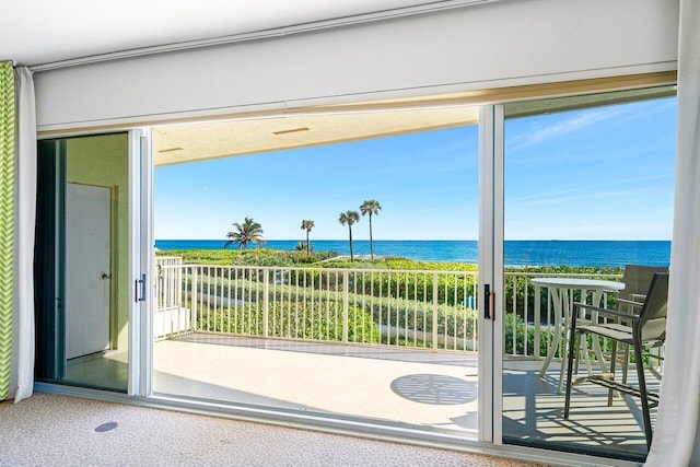 doorway to outside with a water view, carpet floors, and a wealth of natural light