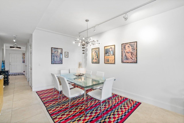 dining room with a chandelier, track lighting, and light tile patterned flooring