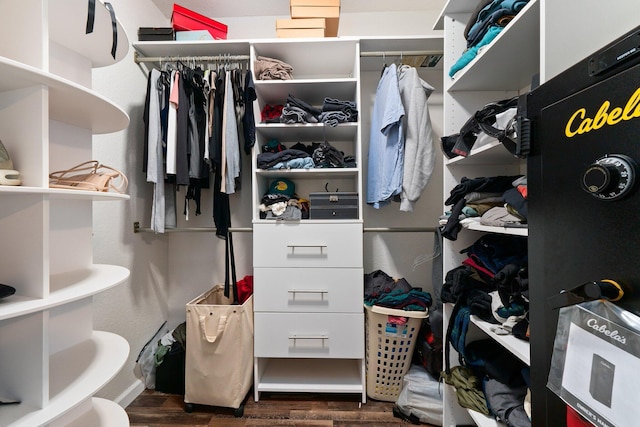 walk in closet with dark wood-type flooring