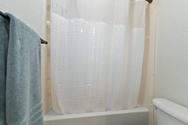 bathroom featuring toilet and shower / tub combo