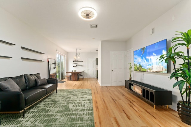 living room with light hardwood / wood-style floors and a chandelier