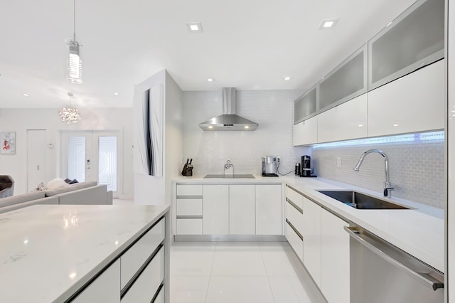 kitchen with white cabinetry, french doors, sink, wall chimney range hood, and stainless steel dishwasher