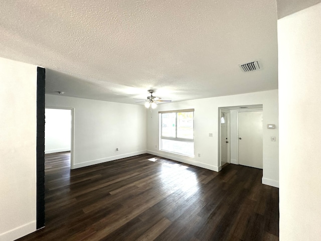 empty room featuring a textured ceiling, dark hardwood / wood-style flooring, and ceiling fan