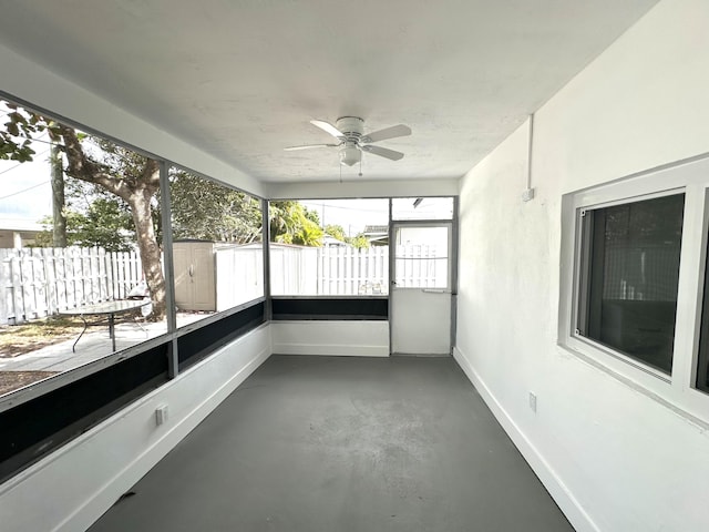 unfurnished sunroom with ceiling fan