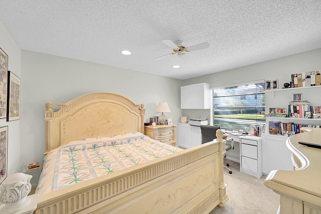 carpeted bedroom featuring ceiling fan and a textured ceiling