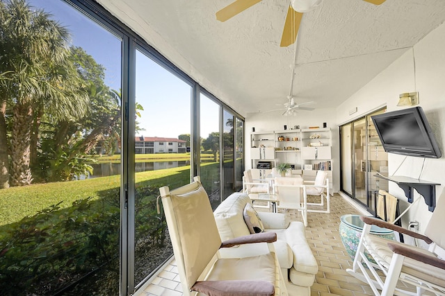 sunroom featuring a water view