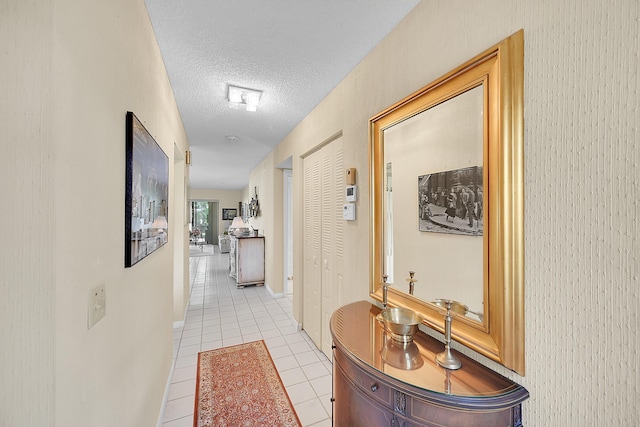 hallway with light tile patterned floors and a textured ceiling