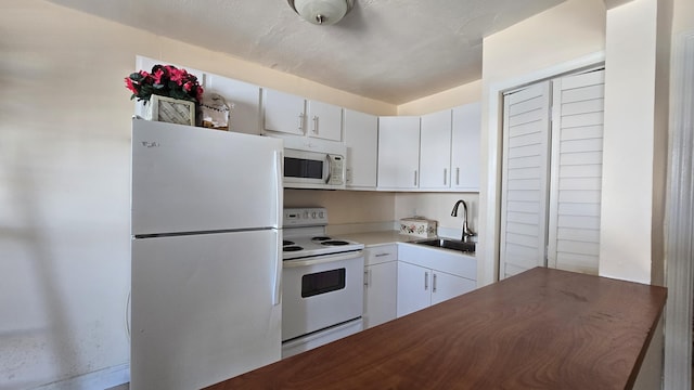 kitchen featuring white cabinetry, white appliances, and sink