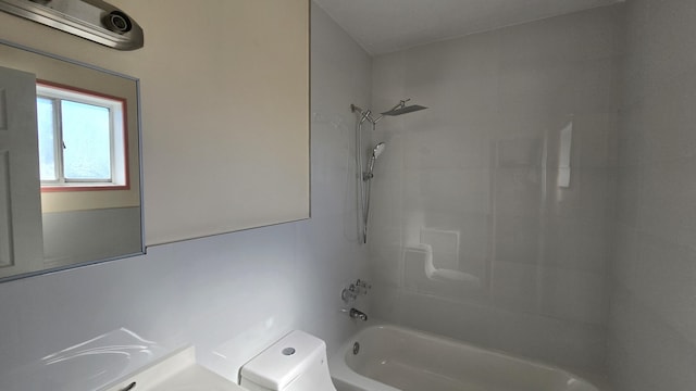 bathroom featuring toilet and tiled shower / bath